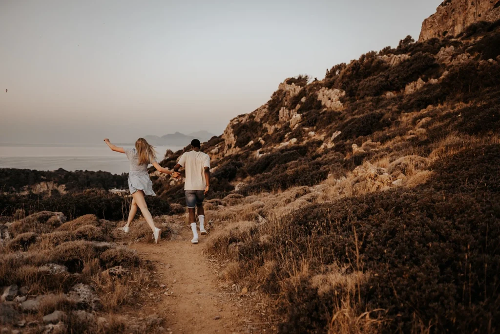 Ein Pärchen, das bei Sonnenaufgang in Rhodos in Griechenland spaziert, fotografiert bei einem Verlobungsshooting