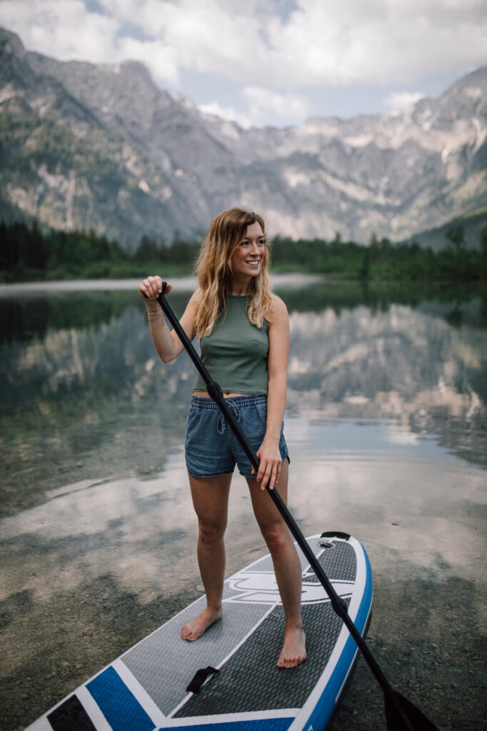 Frau auf einem SUP board mit Bergkulisse am Almsee