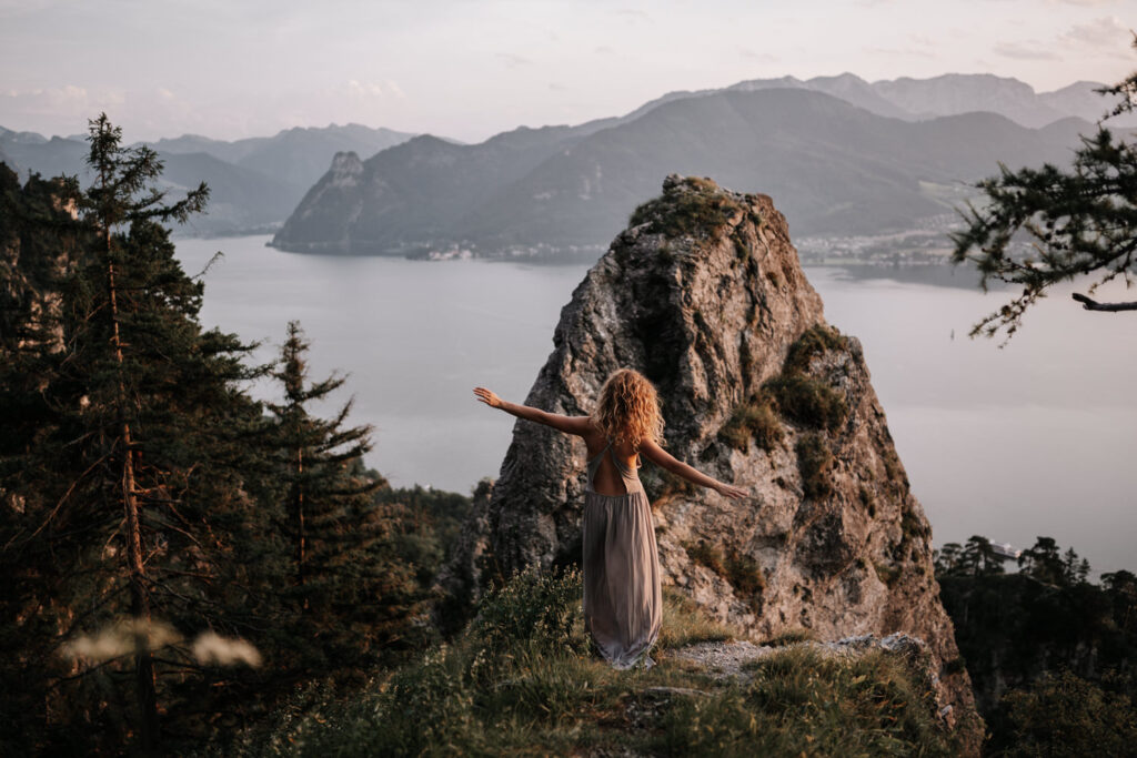 Frau mit Kleid auf einem Berggipfel mit Blick auf den Traunsee in Gmunden im Salzkammergut - Foto von einem Portrait Shooting