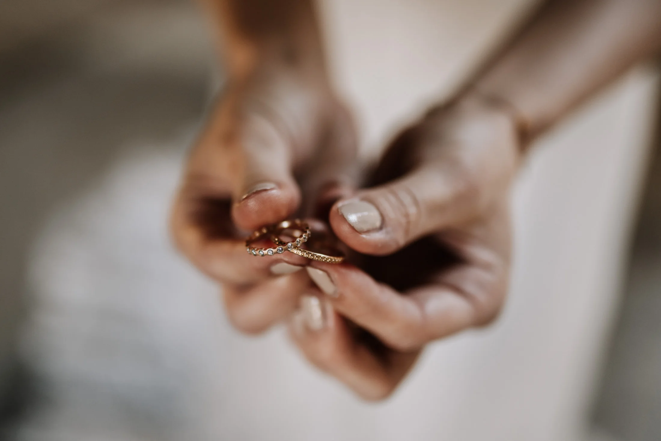 Close-Up von Händen die einen Verlobungsring und einen Ehering halten, fotografiert von Hochzeitsfotograf Nicole Salfinger aus Oberösterreich